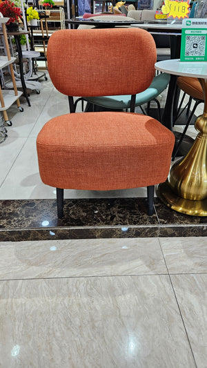 Two orange cushions on a chair with a marble floor and store interior in the background
